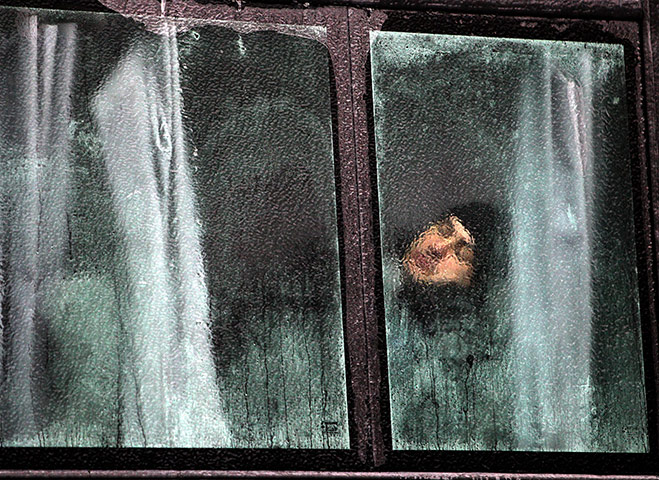 24 hours in pictures: Romanian riot policeman, seen trough the frosted window on bus