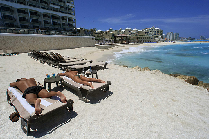 Week in business: Tourists sunbathe in Cancun, a Thomas Cook destination