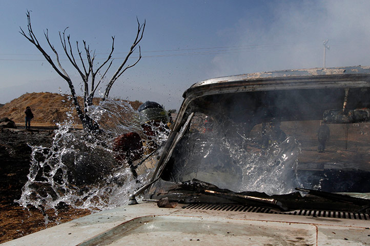 24 hours: A firefighter tries to extinguish a fire in a car