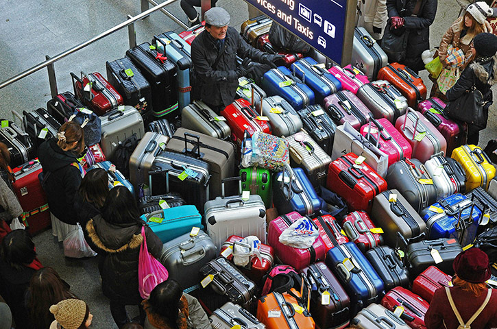Travel Chaos: A passenger reacts as he stands surrounded by luggage