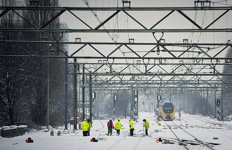 Travel Chaos: Employees of the Dutch railway clear the rail tracks from snow