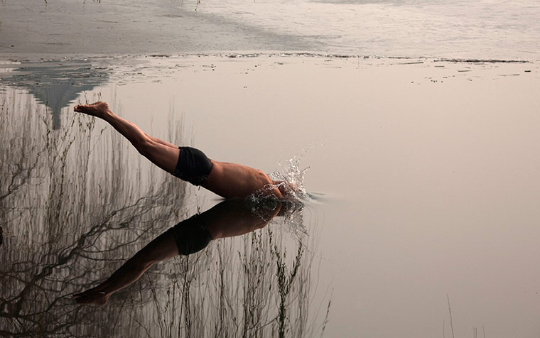 24 hours in pictures: A swimmer dives into the icy waterat Houhai Lake 
