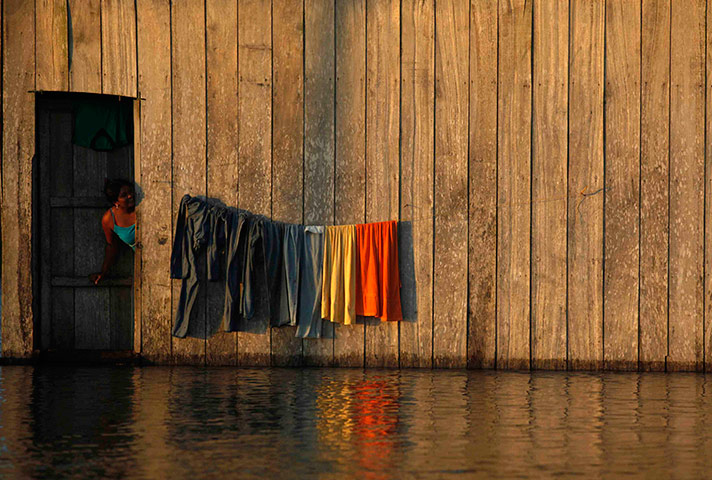 24 hours in pictures: A woman looks out of her house in the flooded in Columbia