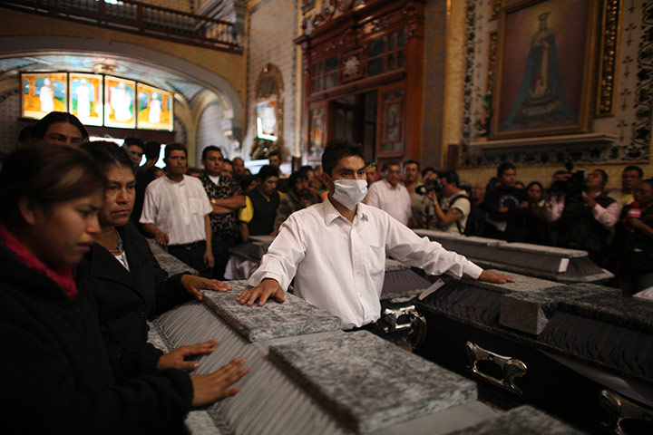 24 hours in pictures: People stand by coffins in San Martin Texmelucan, Mexico,