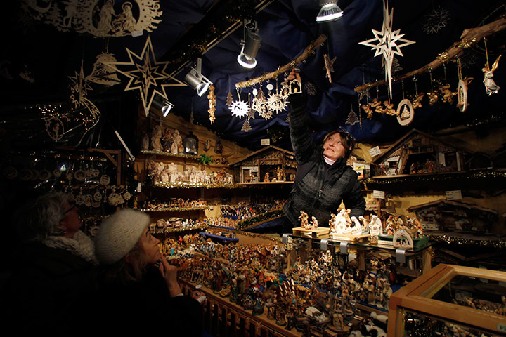 24 hours in pictures: People look at Christmas decorations at a stand at market in Munich