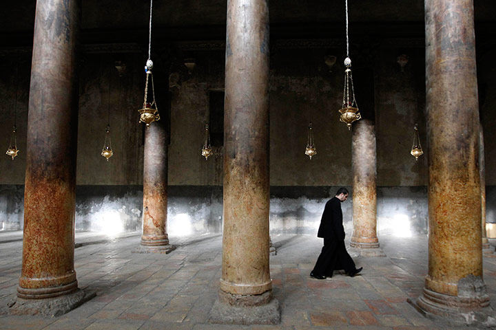 24 hours in pictures: Member of the clergy walks in the Church of the Nativity in Bethlehem