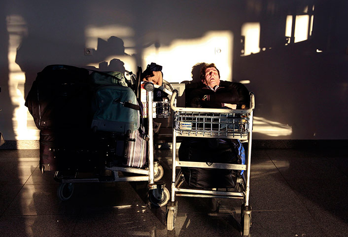 24 hours in pictures: A passenger sleeps at Zaventem international airport near Brussels