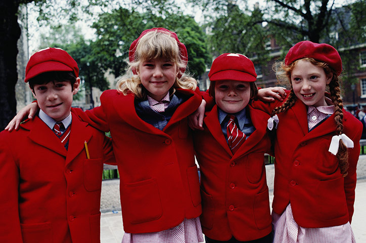 School Uniforms: Four young children show their bright red traditional uniform 