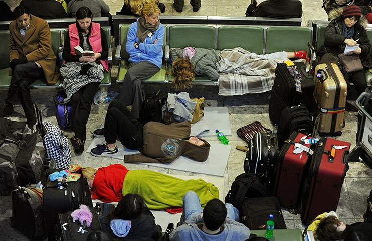Travel Chaos: A passenger lies on the floor, surrounded by luggage