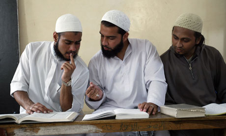 Muslim students discuss before the start of their class at Islamic madrassah Jamia Binori in Karachi