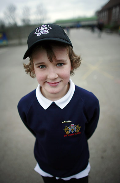 School Uniforms: A young boy stands proudly in his casual uniform with cap
