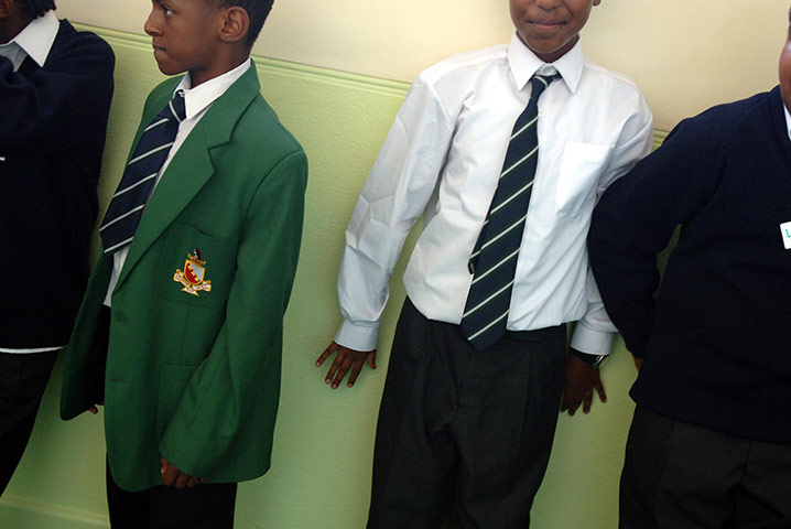 School Uniforms: Boys stand in a school corridor in green blazers and ties