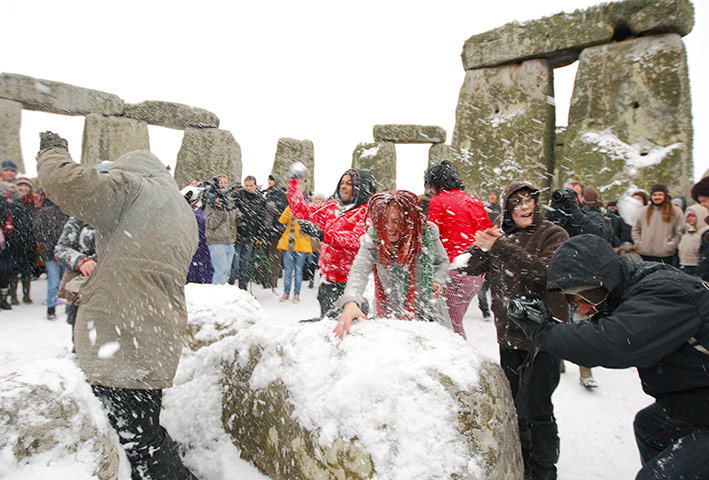 Winter Solstice: People snowball fight during the winter solstice at Stonehenge in Wiltshire