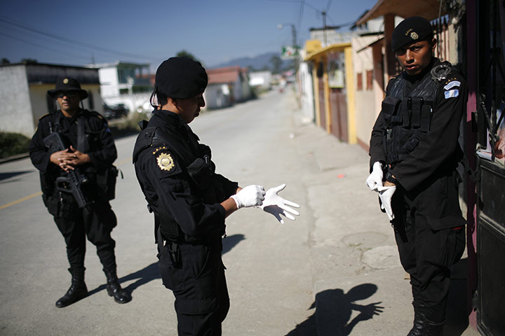24 hours: Coban, Guatemala: Policemen put on synthetic gloves before raiding a house