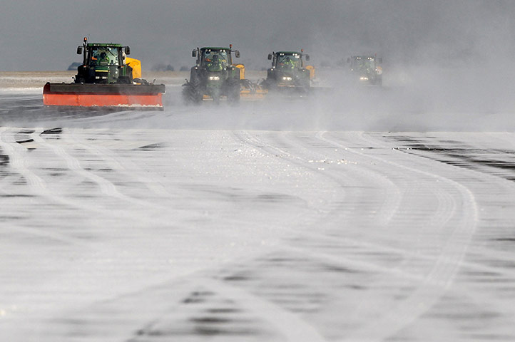 Travel Chaos: Airport workers clear snow from the second runway at Manchester Airport