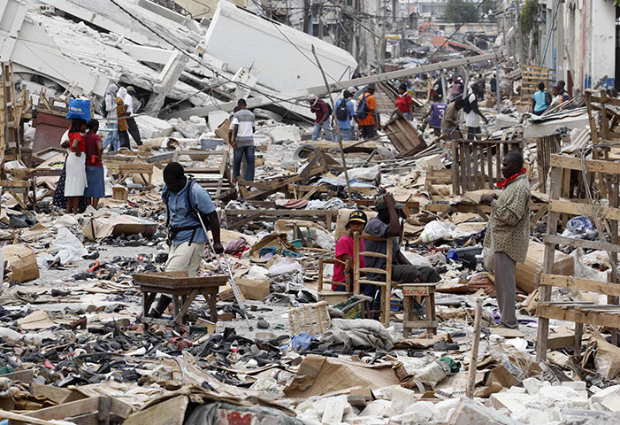 2010 year in MDG: Residents walk in a destroyed area  Port-au-Prince