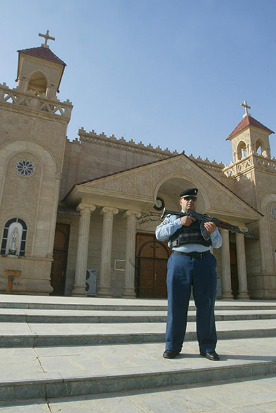 Christian in Middle East: An Iraqi policeman stands guard outside a church in Kirkuk