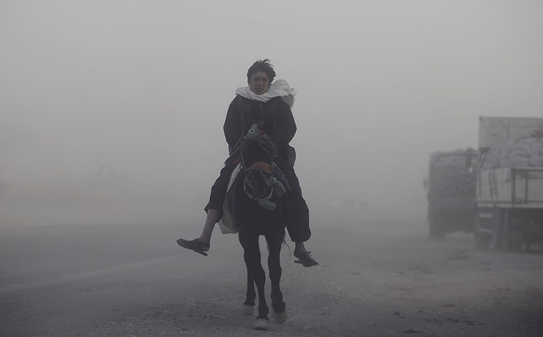 24 hours in pictures: An Afghan worker rides a horse