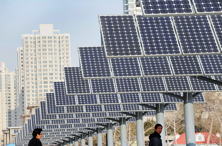 2010 green technologies: Residents walk pass a group of solar panels in Shenyang