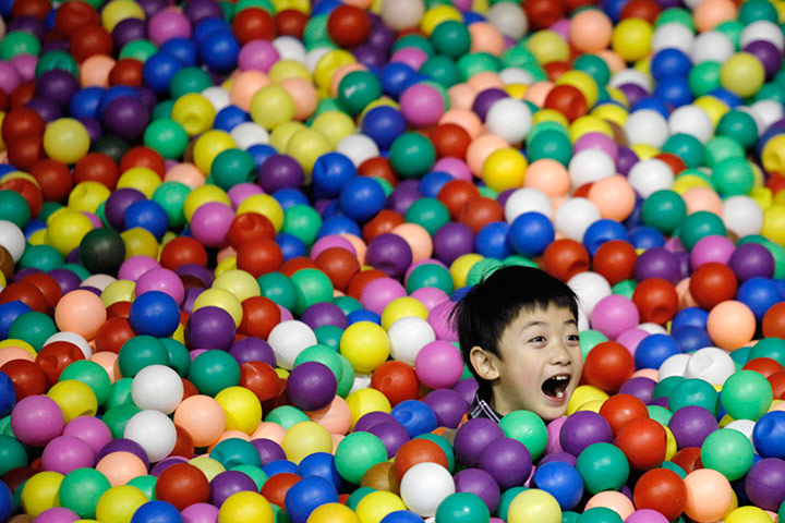 24 hours in pictures: A child plays in a pool of colour balls at an indoor playground in Beijing
