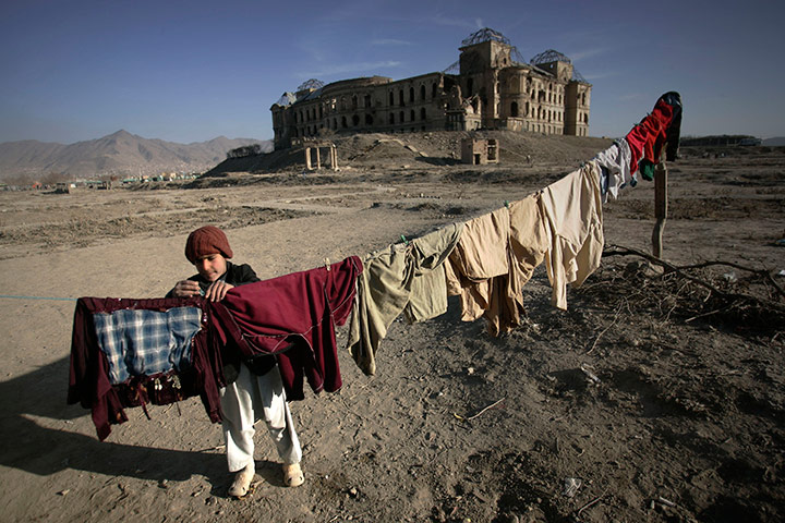 24 hours in pictures: An Afghan refugee boy puts a clip on washed clothes 