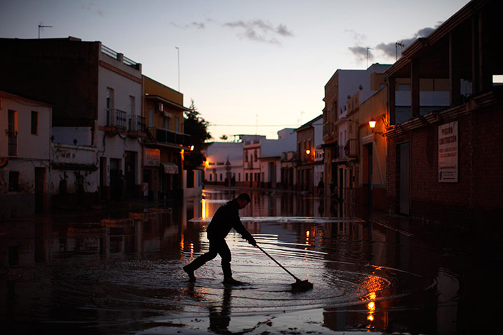 24 hours in pictures: A fireman clears the mud on a flooded street after heavy rains, Spain
