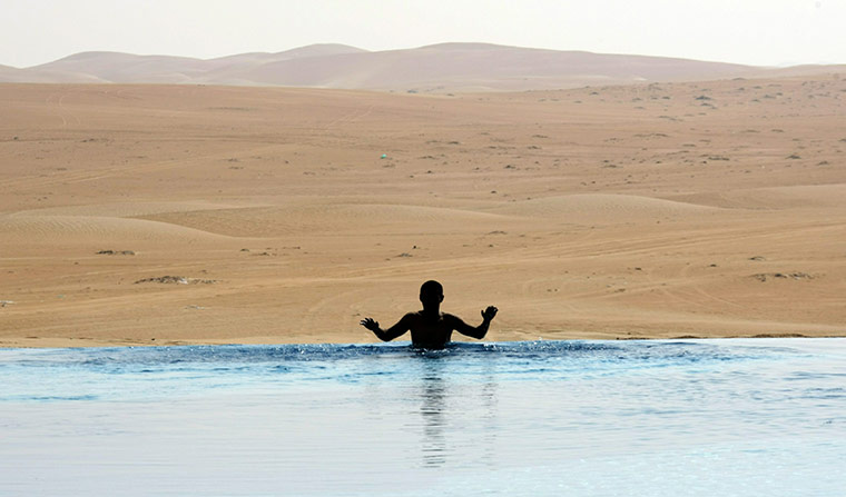 24 hours in pictures: A young man swims in the pool of a hotel in the Liwa Western desert