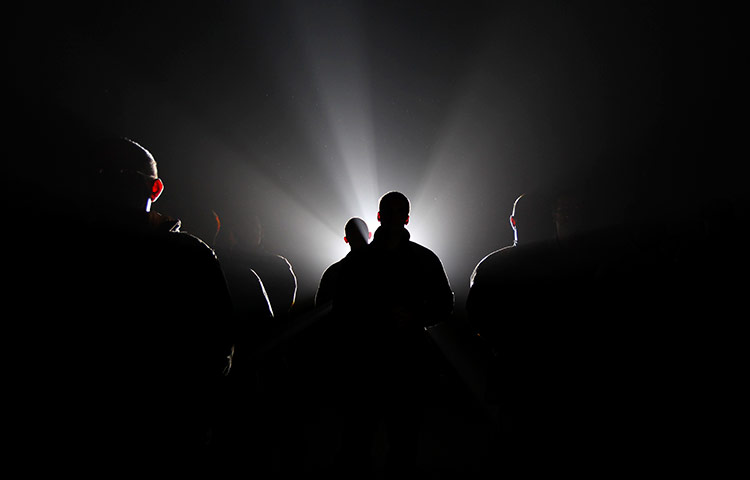 24 hours in pictures:  soldiers are silhouetted against spot light Bagram Air Field, Afghanistan