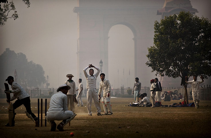 24 hours in pictures: Locals play cricket during near the India Gate monument 