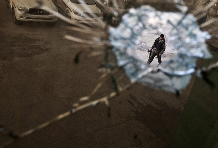 24 hours : Kabul, Afghanistan: A security guard is seen through a bullet hole 