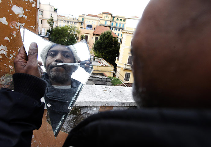 24 hours : Rome, Italy: A Somalian refugee trims his moustache at the former embassy