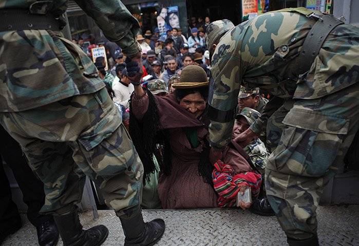 24 hours : El Alto, Bolivia: Soldiers help a woman get into a truck during a strike 