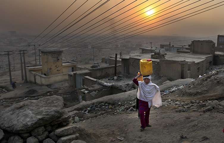 24 hours : Kabul, Afghanistan: An Afghan girl carries water in a plastic container