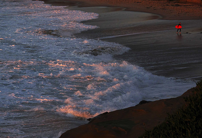 24 hours : La Jolla, California, USA: A surfer in a wet suit leaves the water