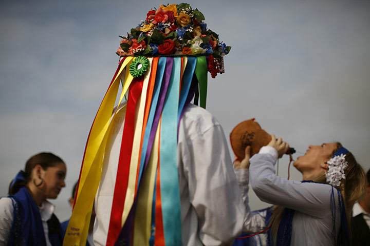 24 hours: Malaga, Spain: People in traditional costume drink wine out of a wineskin