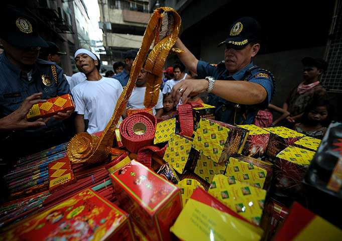 24 hours: Manila, Philippines: A police officer confiscates banned firecrackers
