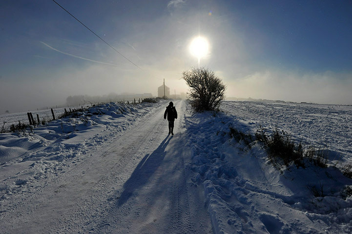 More Snow: A person walks along a snow covered lane