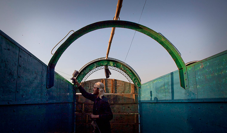 24 hours in pictures: A man applies paint while decorating a supply truck  in Rawalpindi