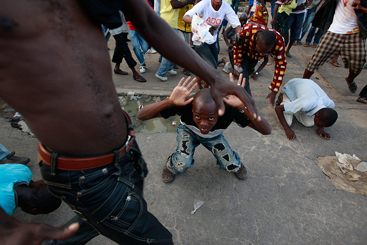 24 hours in pictures: Supporters of opposition leader Alassane Ouattara kneel, Ivory Coast