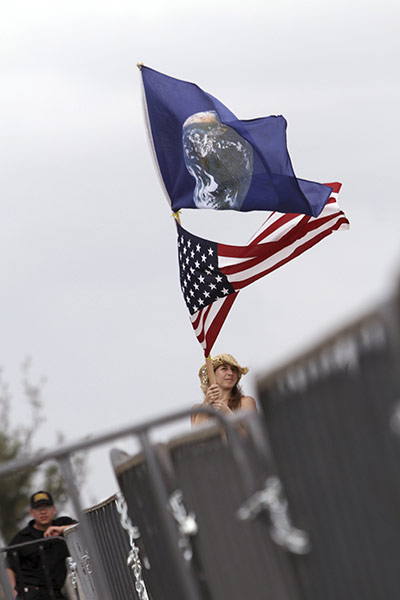 Week in Cancun COP16: A woman waves a U.S. flag and a flag showing the earth  in Cancun