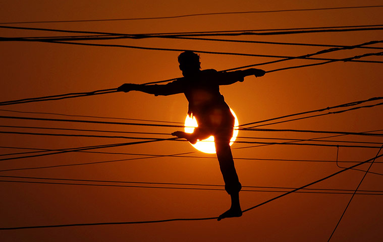 24 hours in pictures: Allahabad, India: An Indian linesman is silhouetted