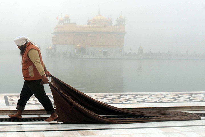 24 hours in pictures: Punjab, India: An Indian Sikh employee cleans the floor
