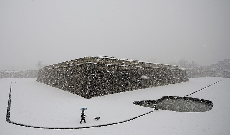 24 Hours: A couple walk in the snow with their dog at Vuelta Castillo Park, Spain