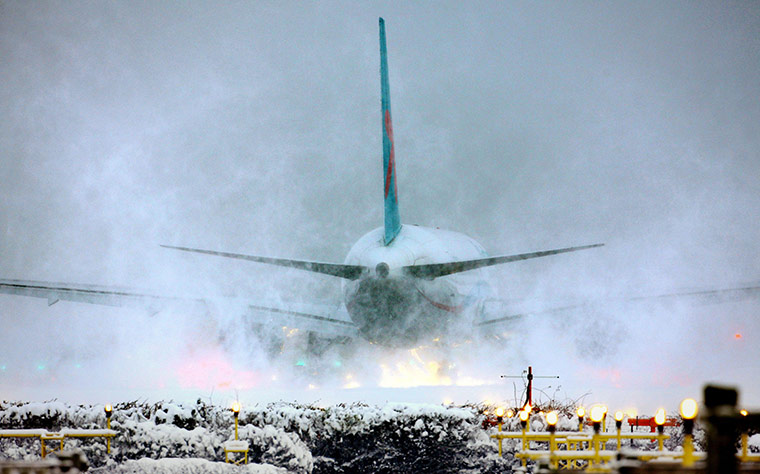 24 Hours: A plane throws up snow as it prepares for takeoff at Gatwick Airport