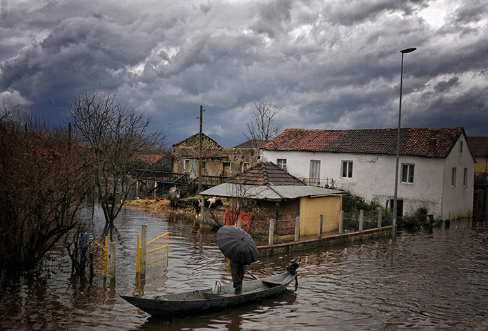 24 Hours: A local villager stands in a boat in the flooded village of Bijelo Polje