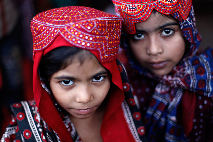 24 hours in pictures: Young girls sport a traditional Sindhi topi in Karachi