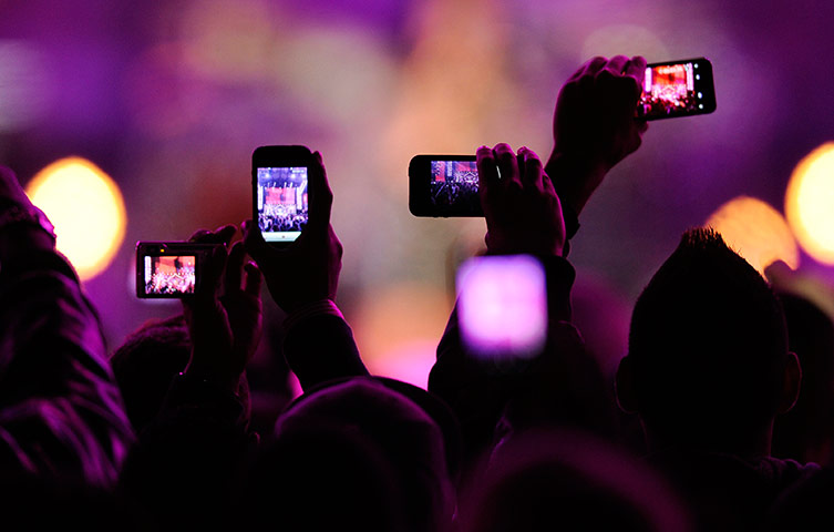 24 hours in pictures: Fans take photos with mobile phones during Divas Salute The Troops show