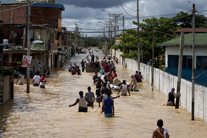 Floods: People evacuate after the flooding of a river in Higuerote, Venezuela
