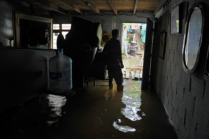 Floods: A man is at the entrance of his flooded house in Buga, Colombia