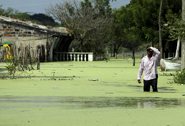 Floods: A man wades through floods caused by heavy rains in Campo de la Cruz